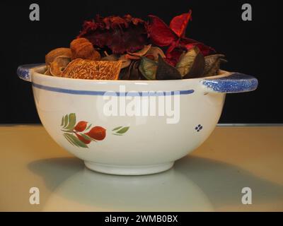 Ein Pot-pourri-Arrangement, dessen Inhalt aus getrockneten, natürlich duftenden Pflanzenmaterialien wie Samenkapseln und Blütenblättern in einer Faience de Quimper-Schüssel gewonnen wird. Stockfoto