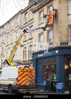 Arbeiter, die eine neue Wandbeleuchtung über der Boston Tea Party am Kingsmead Square, Bath, Somerset, mit einem Kirschpflücker am Van installieren. Stockfoto