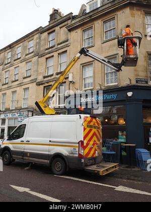 Arbeiter, die eine neue Wandbeleuchtung über der Boston Tea Party am Kingsmead Square, Bath, Somerset, mit einem Kirschpflücker am Van installieren. Stockfoto