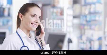 Sie arbeitet in der Apotheke, telefoniert und gibt Ratschläge Stockfoto