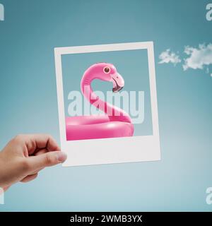 Hand hält ein Vintage-Sofortfoto mit aufblasbarem Flamingo, Sommer- und Urlaubskonzept Stockfoto