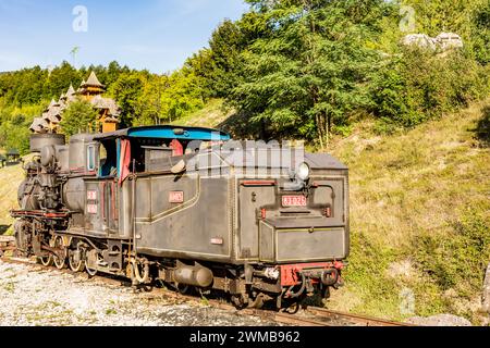 Sonnendurchflutete alte Dampflokomotive am Touristenbahnhof Mokra Gora in Serbien, Reiseziel und Wahrzeichen des Balkans Stockfoto