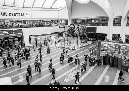 Kunden und Passagiere am Bahnhof Birmingham New Street, gehen und stehen im Hauptfoyer mit Ozzy, dem tobenden Bullen. Stockfoto