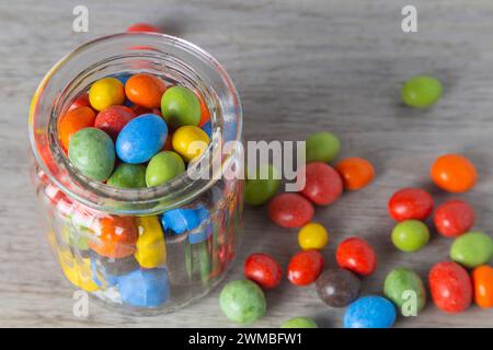 Erdnüsse in Schokoladen-mehrfarbiger Glasur in einem Glasgefäß. Nahaufnahme Stockfoto