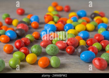 Erdnüsse in Schokolade mehrfarbige Glasur auf einem Holztisch. Nahaufnahme. Stockfoto