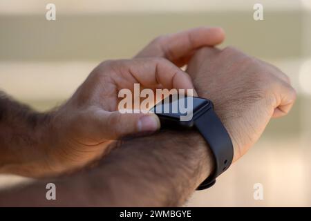 Nahaufnahme männlicher Hände mit Fitnesstracker während des Außentraining Stockfoto