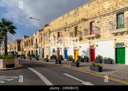 Marsaxlokk, Malta - 22. Dezember 2023: Hausfront in der Innenstadt von Marsaxlokk mit bunten Türen und französischen Türbalkonen Stockfoto