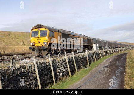 Güterzug mit einem Drax Power Station Badge an der Seite der Siedlung nach Carlisle Railway an den Bleamoor Sidings bei Ribblehead, Yorkshire Dales, Stockfoto