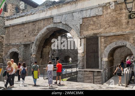 Touristen überqueren das Pretoria-Tor (25 v. Chr.), das römische Stadttor, das von zwei Bögen gebildet wird, die einen Paradeplatz umschließen, Aosta, Aosta-Tal, Italien Stockfoto