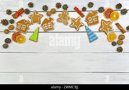 Hausgemachte Lebkuchen in Glasur, Zimt und natürlicher Einrichtung. Draufsicht. Komfort von Familienferien. Weihnachtlicher Hintergrund im rustikalen Stil. Stockfoto