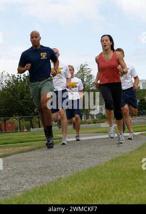 Seattle, Vereinigte Staaten von Amerika. Juli 2009. David Goggins, der erste Klasse der United States Navy Special Warfare betreibende, läuft links neben der Nachrichtensprecherin Lara Yamada, die Q13 Fox TV-Nachrichtensprecherin Lara Yamada, um die bevorstehende Navy SEAL Fitness Challenge am 7. Juli 2009 in Seattle, Washington, zu bewerben. Googins gilt als der „härteste Mann der Welt“ aus seinen extremen Sportarten. Foto: MC2 Michelle Kapica/US Navy Photo/Alamy Live News Stockfoto