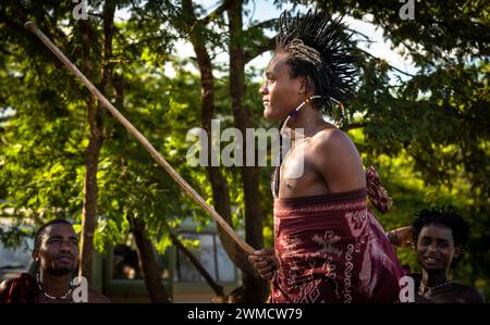 Ein Maasai-Krieger hält seinen Ol-nkerr-Stock, während er singt und den traditionellen Springtanz in seinem Dorf in Mikumi, Tansania, aufführt Stockfoto