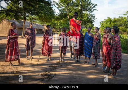 Eine Gruppe von Maasai-Kriegern singen und führen den traditionellen Springtanz in ihrem Dorf in Mikumi, Tansania, auf Stockfoto