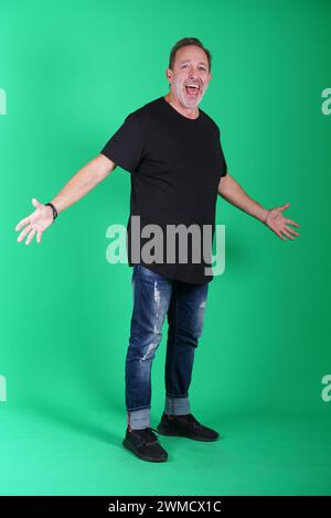 Echte Menschen, Mann in seinen 50ern, der lässige Kleidung trägt, sich auf dem grünen Bildschirm des Studios posiert, eine Vielzahl von Emotionen und Körperpositionen, voller Körper und Stockfoto