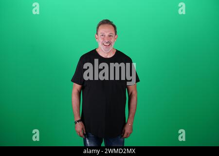Echte Menschen, Mann in seinen 50ern, der lässige Kleidung trägt, sich auf dem grünen Bildschirm des Studios posiert, eine Vielzahl von Emotionen und Körperpositionen, voller Körper und Stockfoto