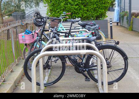 Dublin, Irland - 24. Februar 2024: Ein Foto von mehreren Fahrrädern, die neben einem Fahrradträger aus Metall auf einem Weg in einem Park in Dublin geparkt sind. Stockfoto