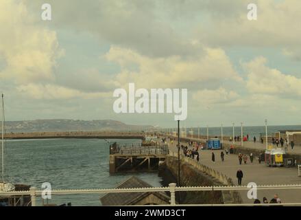 Dublin, Irland - 24. Februar 2024: Ein breites Landschaftsfoto des westlichen Piers in Dún Laoghaire während eines orangen Abendhimmels. Stockfoto