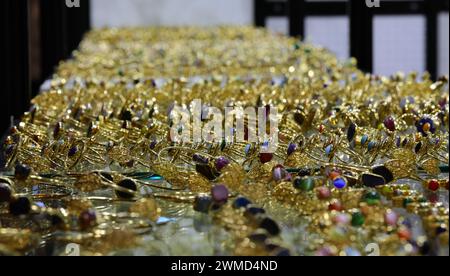 goldene Ringe und Armbänder mit Edelsteinen im Schaufenster des Modeschmucks zum Verkauf Stockfoto