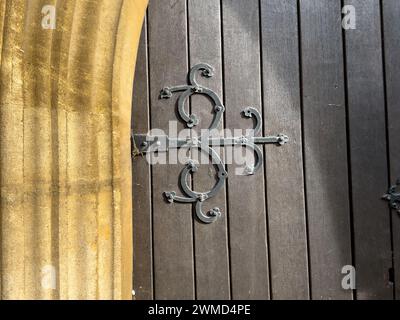 Das Bild zeigt eine Nahaufnahme der Holztür von St. Mary's Church in Thatcham, Berkshire, verziert mit dekorativen Metallbeschlägen. Konstruiert Stockfoto