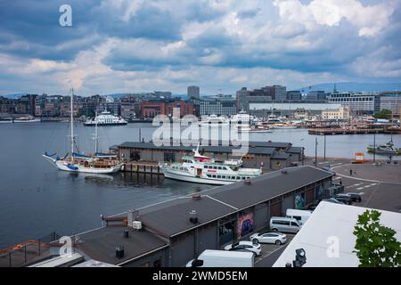 Oslo, Norwegen, 19. Juni 2023: Aus der Vogelperspektive auf den Oslo-Fjord und die Handelsboote, die an nahe gelegenen Docks ankern, mit der Skyline der Stadt im Hintergrund während eines Stockfoto