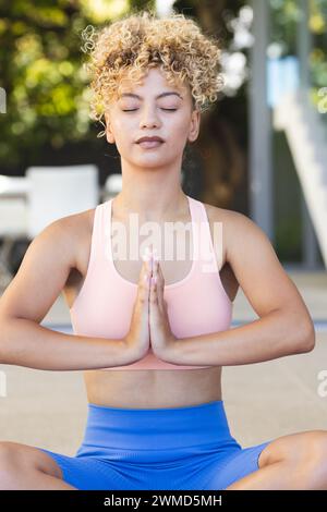 Junge birassische Frau praktiziert Yoga im Freien Stockfoto