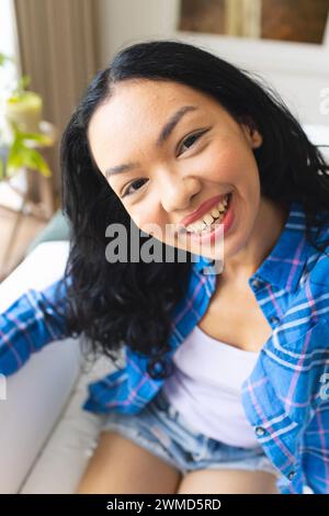 Die junge Frau lächelt zu Hause hell Stockfoto