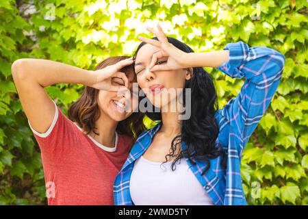 Zwei junge Frauen machen im Freien spielerische Gesten Stockfoto