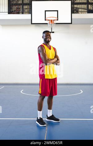 Junger Afroamerikaner steht selbstbewusst auf einem Basketballfeld, mit Kopierraum Stockfoto