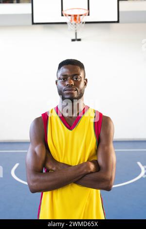 Ein junger Afroamerikaner steht selbstbewusst auf einem Basketballfeld Stockfoto