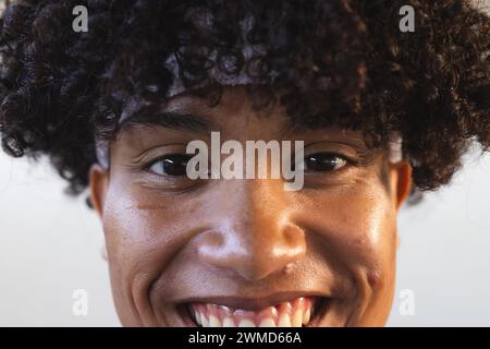 Nahaufnahme eines jungen Menschen mit Rasse, der hell lächelt Stockfoto