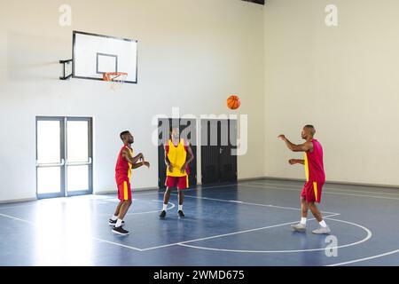 Drei Afroamerikaner spielen Basketball in der Halle Stockfoto