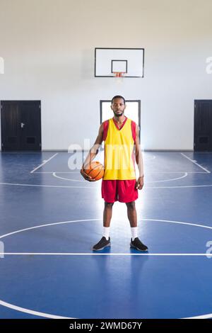 Afroamerikaner steht selbstbewusst auf einem Basketballfeld Stockfoto