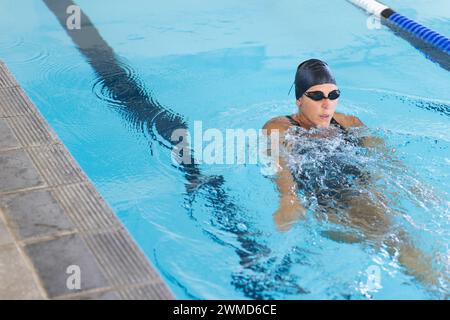 Eine weiße Sportlerin schwimmt in einem Pool, mit Kopierraum Stockfoto