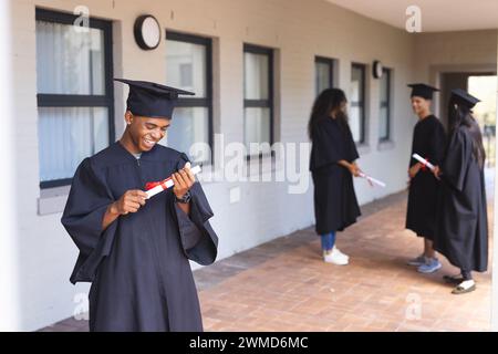 Ein birassischer Teenager in Abschlusskleidung an der Highschool Stockfoto