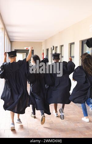 Verschiedene Schüler feiern den Abschluss an der High School mit Kopierraum Stockfoto