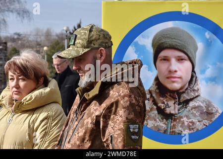 Zaporischzhia, Ukraine. Februar 2024. Verwandte und Freunde sind am Portraitstand des gefallenen ukrainischen Soldaten im Zentrum von Zaporischschschiha zu sehen. Der ukrainische Präsident Wolodymyr Zelenski hat den zweiten Jahrestag der russischen Invasion begangen, indem er sagte, sein Land werde erfolgreich sein. Die Ukraine widersetzte sich den Prognosen, Russland zu bekämpfen, aber es gibt Anzeichen dafür, dass sich der Krieg zu Gunsten Russlands wendet. Die ukrainische Regierung hat längst aufgehört, die Zahl ihrer Toten zu teilen. Aber die ständig wachsende Zahl frischer Gräber auf beiden Seiten der Frontlinie zeichnet ein schmerzhaft klares Bild Stockfoto