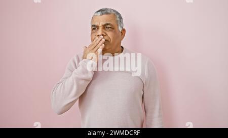 Mann mittleren Alters mit grauen Haaren, nachdenklich vor einem rosa isolierten Hintergrund. Stockfoto