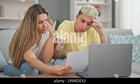 Wunderschönes Paar, das ein Notebook benutzt, um Dokumente zu lesen und zu Hause verärgert zu sein Stockfoto