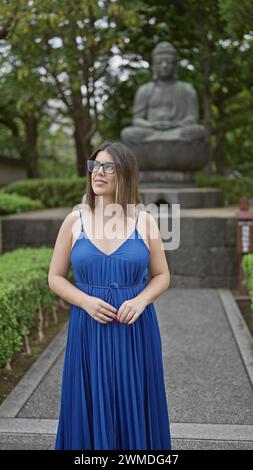 Fröhliche, wunderschöne hispanische Frau mit Brille, die freudig den majestätischen Senso-JI-Tempel erkundet und bewundert, während sie lässig schlendert und sich umsieht Stockfoto