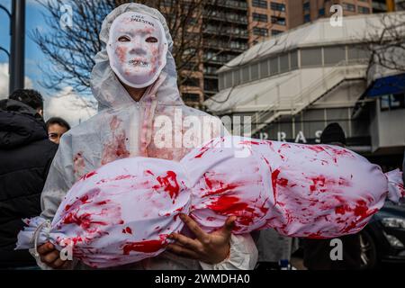 Rotterdam, Süd-Holland, Niederlande. Februar 2024. Ein Demonstrant, bedeckt mit gefälschtem Blut, hält einen symbolischen Körper eines toten Kindes. Am 25. Februar 2024 versammelten sich pro-palästinensische Demonstranten auf der Binnenrotte in Rotterdam, Niederlande. Sie verlangten Israel, seine Hände von Rafah zu lassen. (Kreditbild: © James Petermeier/ZUMA Press Wire) NUR REDAKTIONELLE VERWENDUNG! Nicht für kommerzielle ZWECKE! Stockfoto