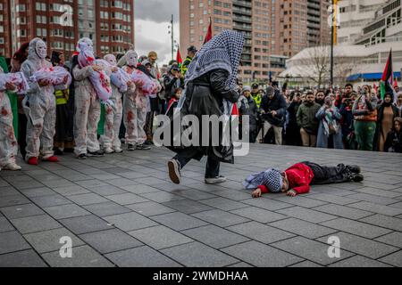 Rotterdam, Süd-Holland, Niederlande. Februar 2024. Eine Frau und ein Kind spielen eine Szene, in der das Kind durch einen arial-Bombenanschlag getötet wird. Am 25. Februar 2024 versammelten sich pro-palästinensische Demonstranten auf der Binnenrotte in Rotterdam, Niederlande. Sie verlangten Israel, seine Hände von Rafah zu lassen. (Kreditbild: © James Petermeier/ZUMA Press Wire) NUR REDAKTIONELLE VERWENDUNG! Nicht für kommerzielle ZWECKE! Stockfoto