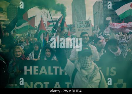 Rotterdam, Süd-Holland, Niederlande. Februar 2024. Ein Demonstrant hält eine grüne Rauchbombe vor einer Demonstrationsgruppe pro-palästinensischer Demonstranten. Am 25. Februar 2024 versammelten sich pro-palästinensische Demonstranten auf der Binnenrotte in Rotterdam, Niederlande. Sie verlangten Israel, seine Hände von Rafah zu lassen. (Kreditbild: © James Petermeier/ZUMA Press Wire) NUR REDAKTIONELLE VERWENDUNG! Nicht für kommerzielle ZWECKE! Stockfoto