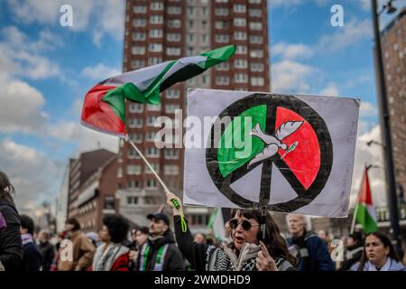 Rotterdam, Süd-Holland, Niederlande. Februar 2024. Ein Demonstrant hält ein Schild mit der Friedenstaube und einem Schild, während er eine palästinensische Flagge schwenkt. Am 25. Februar 2024 versammelten sich pro-palästinensische Demonstranten auf der Binnenrotte in Rotterdam, Niederlande. Sie verlangten Israel, seine Hände von Rafah zu lassen. (Kreditbild: © James Petermeier/ZUMA Press Wire) NUR REDAKTIONELLE VERWENDUNG! Nicht für kommerzielle ZWECKE! Stockfoto