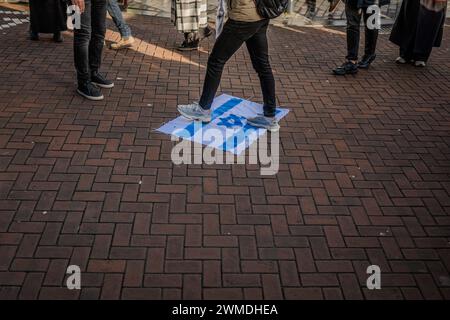 Rotterdam, Süd-Holland, Niederlande. Februar 2024. Ein palästinensischer Demonstrant tritt auf eine handgemachte israelische Flagge. Am 25. Februar 2024 versammelten sich pro-palästinensische Demonstranten auf der Binnenrotte in Rotterdam, Niederlande. Sie verlangten Israel, seine Hände von Rafah zu lassen. (Kreditbild: © James Petermeier/ZUMA Press Wire) NUR REDAKTIONELLE VERWENDUNG! Nicht für kommerzielle ZWECKE! Stockfoto