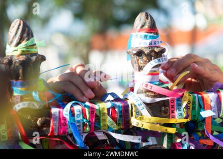 Salvador, Bahia, Brasilien - 29. Dezember 2023: Menschen, die Senhor do Bonfim huldigen, werden gesehen, indem sie ein Souvenirband an das Eisengeländer der Kirche binden Stockfoto