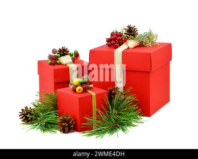 Rote Geschenkboxen mit gefrorenen Beeren und Bändern, Tannenzweigen und Kegeln, Isolierung auf weißem Hintergrund. Weihnachten. Neujahr. Stockfoto