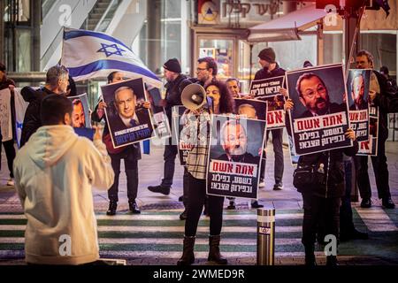 Tel Aviv, Israel. Februar 2024. Anhänger des israelischen Ministerpräsidenten Benjamin Netanjahu halten Schilder mit der Aufschrift "du bist verantwortlich für das Zerreißen des Landes" und beziehen sich auf den ehemaligen Premierminister Ehud Barak während eines Protestes. Etwa 50 Demonstranten versammelten sich zur Unterstützung von Premierminister Netanjahu, als Tausende Israelis am Samstag in Tel Aviv gegen den israelischen Premierminister Benjamin Netanjahu und seine Regierung protestierten und die Regierung aufforderten, eine Vereinbarung über den Austausch von Geiseln der Hamas und Israels zu treffen. (Foto von Eyal Warshavsky/SOPA Images/SIPA USA) Credit: SIPA USA/Alamy Live News Stockfoto