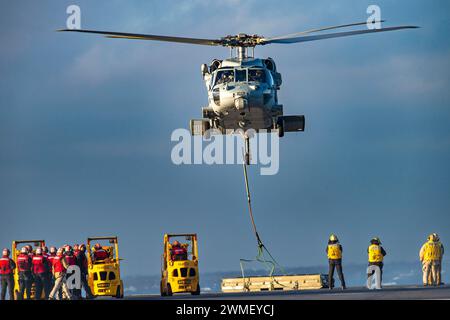 240221-N-TY639-1152 ATLANTIC OCEAN, Va. (21. Februar 2024) ein MH-60S Sea Hawk Helikopter, der den 'Dragonslayers' der Helicopter Sea Combat Squadron (HSC) 11 zugeordnet ist, platziert während einer vertikalen Auffüllung am 21. Februar 2024 Fracht auf dem Flugdeck des Flugzeugträgers USS Harry S. Truman (CVN 75) der Nimitz-Klasse. Truman ist das Flaggschiff der Harry S. Truman Carrier Strike Group und wird derzeit als Teil der Basisphase auf dem Weg gebracht. (Foto: Matthew Nass, Spezialist für Massenkommunikation, 2. Klasse) Stockfoto