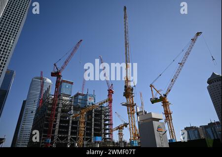 Peking, China. Februar 2024. Mehrere Kräne stehen auf einer Baustelle zwischen Hochhäusern im Geschäftsviertel Pekings in der Nähe der U-Bahn-Station Guomao. Quelle: Johannes Neudecker/dpa/Alamy Live News Stockfoto