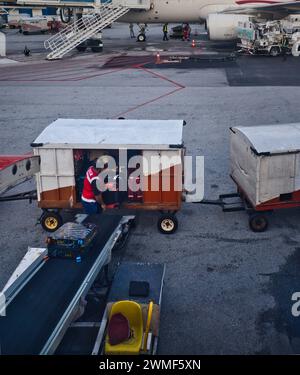 Kuala Lumpur, Malaysia - 21. Dezember 2023: Flughafenbesatzung, die ihre Arbeit auf dem Asphalt, Gepäckabfertigung, Betanken, Kontrolle der Flugzeuge ausführt. Stockfoto